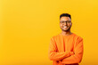 © Vadim Pastuh - Successful smiling indian man freelancer or student posing indoors with crossed arms, confident guy looking at camera, arabian young male employee in glasses isolated on yellow