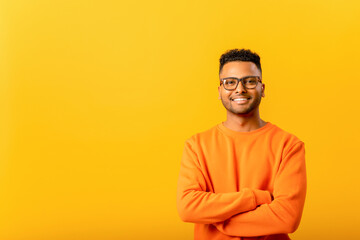 successful smiling indian man freelancer or student posing indoors with crossed arms, confident guy 