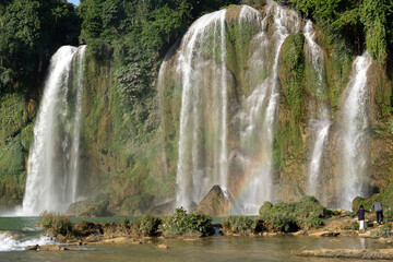 Northern Vietnam, the famous Ban Gioc Waterfall. Situated on the Vietnamese - Chinese boarder. A  couple walks near the falls.