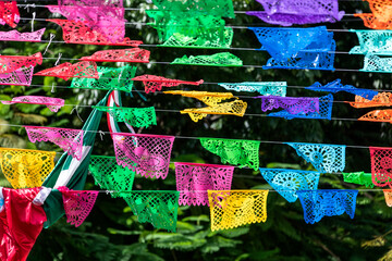 The Mexican flag along with small flags in the middle of the fifth avenue of Playa del Carmen in Mexico, this is a very busy place for tourists to enjoy their summer vacations.