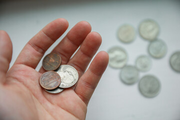 dollar and coins with hand showing the current finance and economy of the us market including the banks depicting savings and loans and the financial struggle to invest and success 