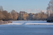 Blick über den zugefrorenen Sprinbrunnenteich im verschneiten Stadtgarten auf das Marienhospital in Bottrop
