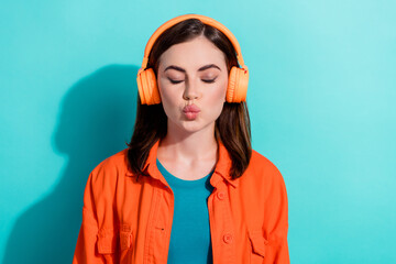 Canvas Print - Photo of dreamy tender lady eyes closed wear orange stylish modern device listen romantic hits isolated on aquamarine color background