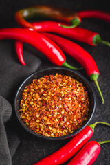 Sticker - Dry chili pepper flakes. Crushed red peppers in bowl on black table.