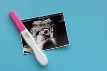 Pregnancy Test And Baby Ultrasound Photo Scan Photo On Blue Background. Family Planning And Antenatal Care, Health Check Concept.