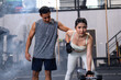 Male fitness center instructor help woman lifting dumbbell workout at fitness center