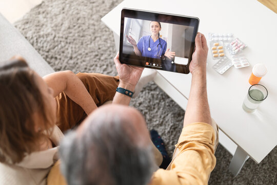 using ehealth and telemedicine services at home. senior couple using digital tablet having video cal