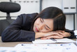 © Fahng - Lazy business woman sleeping on desk in office.