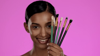 Wall Mural - Beauty, makeup and Indian woman with brushes in studio, happiness and smile isolated on pink background. Skincare, creative facial cosmetics and happy skin care model with luxury spa or salon product