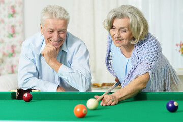 Poster - Happy senior couple playing billiards together in home