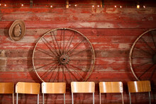 Chairs Against Wheels Hanging On Wooden Wall