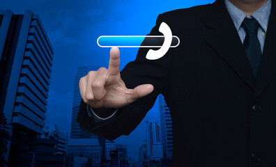 Businessman pressing phone icon with copy space for add your phone number over modern office city tower and skyscraper, Business contact us concept