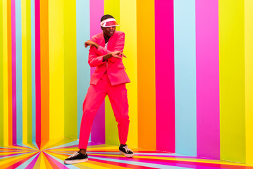 Beautiful african american young woman dancer having fun inside a rainbow box room - Cool and stylish black adult female portrait on colorful background, influencer creating content for social media