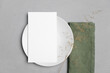 Wedding paper blank menu card mockup on white plate with botanical decor, mockup with copy space