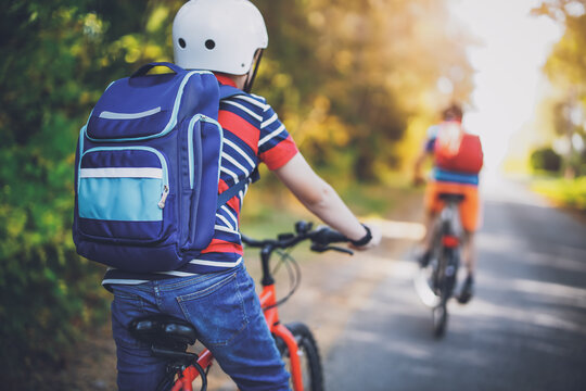 Fototapete - Children riding on bicycles on asphalt road in summer.