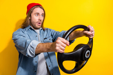 Poster - Photo of astonished impressed guy dressed jeans shirt hold steering wheel look at accident empty space isolated on yellow color background