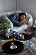 © Johnér - Pensive young woman lying on sofa and using phone