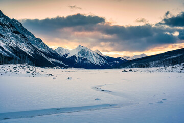 Wall Mural - Sunrise over Medicine Lake with rocky mountains and frozen lake in Jasper national park