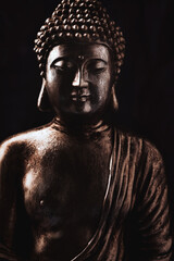 Wall Mural - Meditating Buddha Statue on dark background. Soft focus. Close up. Copy space.	