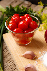 Wall Mural - Homemade pickled tomatoes. Bowl of canned tomatoes. Marinated vegetables in a glass jars on background.