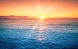 Beautiful orange sunset with sun rays, blue ocean water, calm weather sunny day.