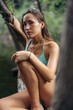 © ADDICTIVE STOCK - Calm woman sitting on tree trunk near lake