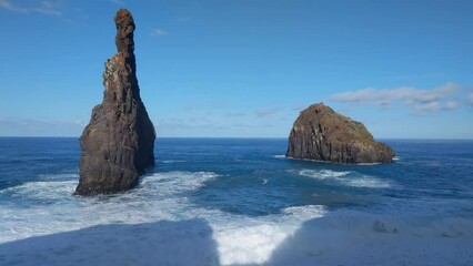 Wall Mural - Rocks stick out of the water. The waves wash the rock