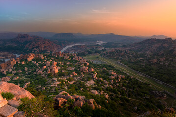 Wall Mural - Beautiful view of boulder strewn landcape and ruins at sunrise at Hampi