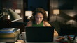 © stockbusters - Serious woman making notes evening house closeup. Involved girl watching laptop