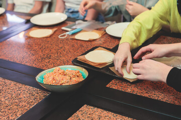 Group of children in a cooking class, kids preparing asian style food in the kitchen together, kids in aprons learn cooking on master class, chef uniform, hands in gloves