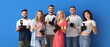 © Pixel-Shot - Group of happy young photographers showing thumb-up gesture on blue background