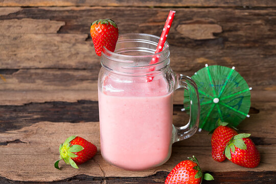 Fototapete - Strawberry yogurt fruit juice smoothie pink colorful fruit juice milkshake blend beverage healthy high protein the taste yummy In glass drink episode morning on wood background.