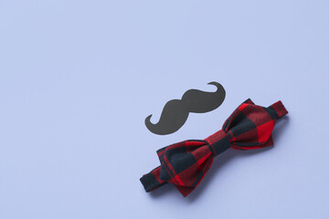 Paper mustache and stylish male bow tie on color background