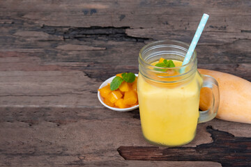 Mango juice fruit smoothies yogurt drink yellow healthy delicious taste in a glass slush for weight loss on wooden background.