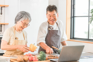 Sticker - 家のキッチンでノートパソコンを使いながら料理を作るシニア・高齢者夫婦（自炊・手料理）
