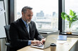 © Kawee - Caucasian senior businessman working on table in the office workplace. Attractive elderly mature male employee worker people sit alone with confidence and typing laptop computer at company corporation