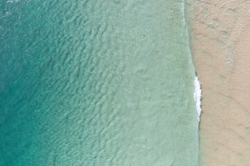 Poster - Aerial view of a beach with gentle waves and white sand in a tropical wonderland