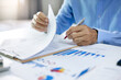 © Lek - Asian businessman read business contract and checking investment chart before sign to start new business and start new investment project in the future