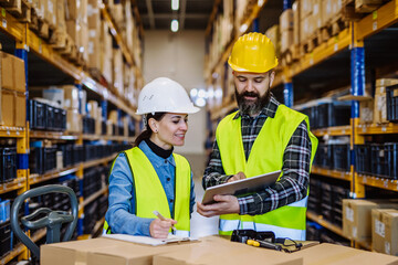 Wall Mural - Warehouse workers checking stuff in warehouse with digital system in tablet, holding solar panel.