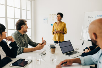 Canvas Print - Group of diverse business people discussing a project in a meeting