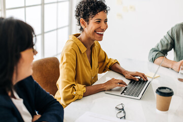 Wall Mural - Business woman using a laptop in a boardroom meeting