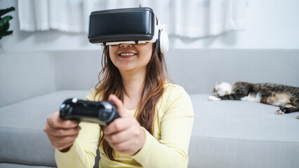 Young Asian woman gamer wearing virtual reality touching air during the VR experience  Future home technology player hobby playful enjoyment concept.