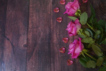 Aufkleber - pink rose flowers with glass hearts on a dark wooden background. Free space for text insertion. Postcard concept