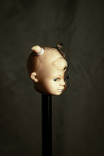 Damaged Dirty Burnt Doll Head On Grey Background