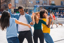 Multi Ethnic Young Friends Dancing In A City Square, Authentic Group Of Diverse Friends Having Fun