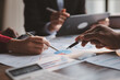 © kamiphotos - Group business people are brainstorming together and reviewing the company financial documents that the finance department has summarized, they are business partners. Business administration concept.