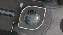 A Top Down View Directly Above An Office Complex On Long Island, New York With Green Glass Skylights. The Drone Camera Tilted Straight Down, Pan Left Slowly Keeping The Entrance Rotunda Centered.