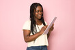 © Danko - Young smiling happy african american girl teen student wear casual clothes hold books isolated on pink color background studio portrait. Education in high school university college concept.