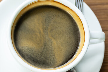 Top view Hot coffee in the white cup  on wooden table background..Cafe drinking menu black coffee at the restaurant with copy space.