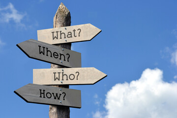 Canvas Print - What?, when?, who?, how? - wooden signpost with four arrows, sky with clouds